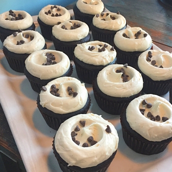 A photo of chocolate cake with vanilla frosting cupcakes.